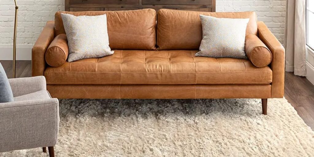 Shag area rug underneath a light brown leather couch